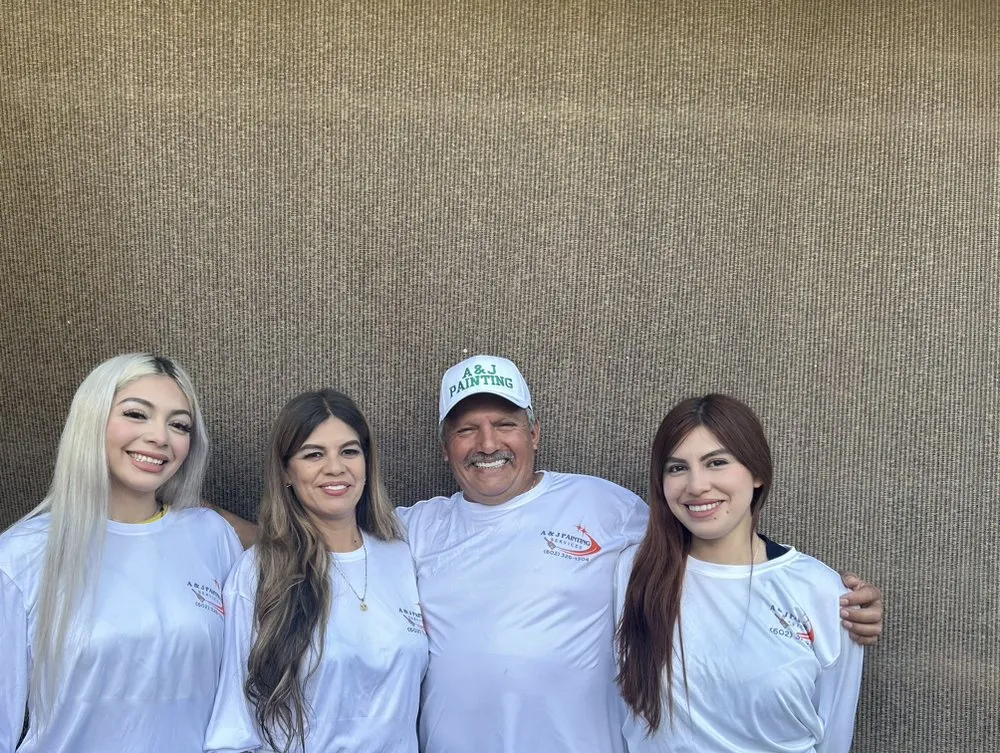 A & J Painting Services family team standing together in branded shirts